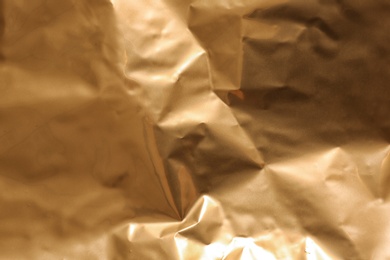 Crumpled golden paper as background, closeup view