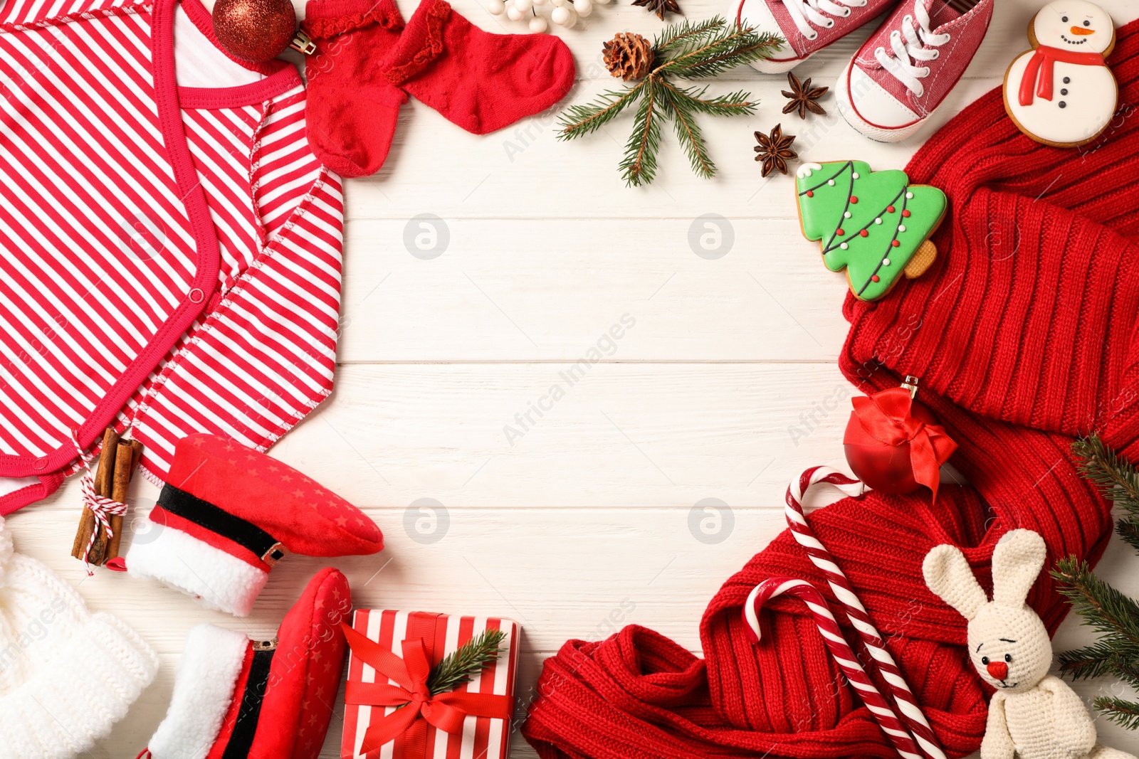 Photo of Flat lay composition with cute Christmas baby clothes on white wooden background. Space for text