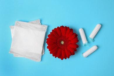 Different feminine hygiene products and flower on color background, flat lay. Gynecological care