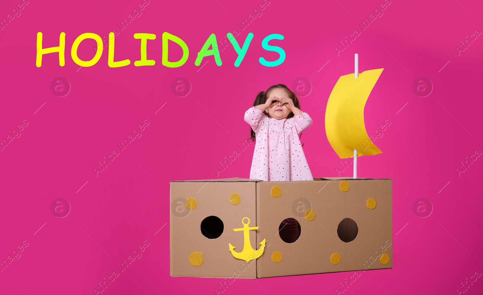 Image of School holidays. Cute little child playing with cardboard ship near pink wall. Banner design 