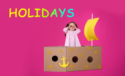 Image of School holidays. Cute little child playing with cardboard ship near pink wall. Banner design 