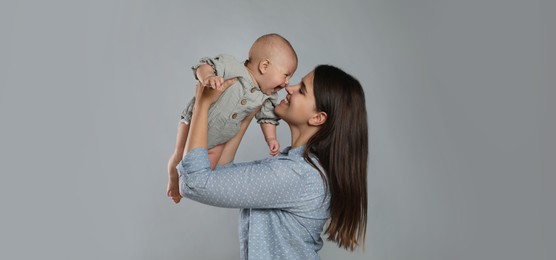 Image of Beautiful mother with her cute baby on grey background. Banner design 