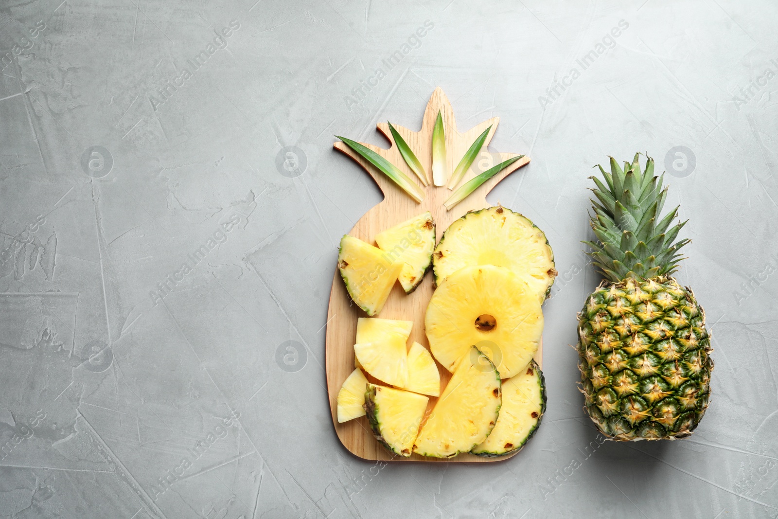 Photo of Flat lay composition with fresh sliced pineapple on gray background