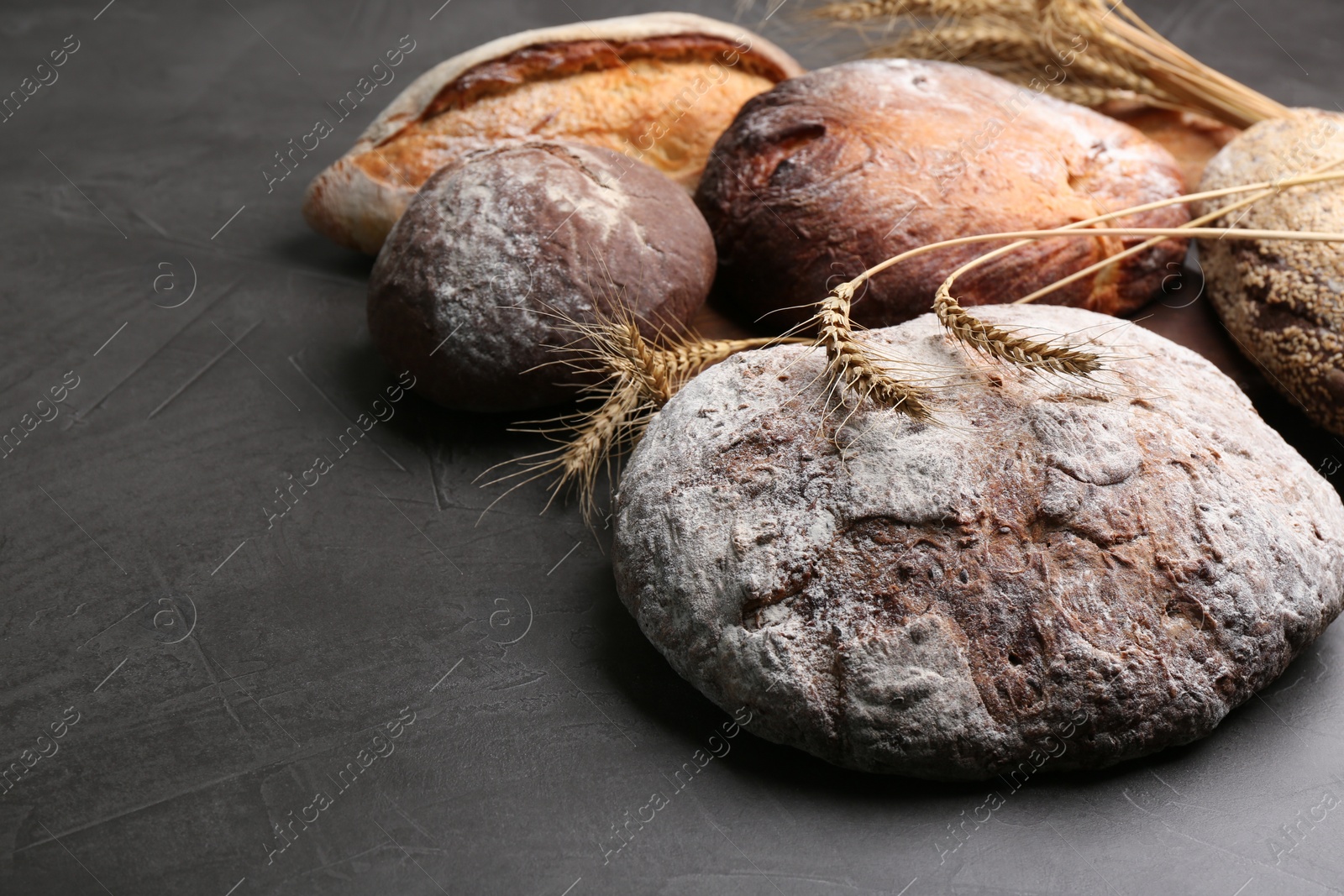 Photo of Different kinds of fresh bread on grey table