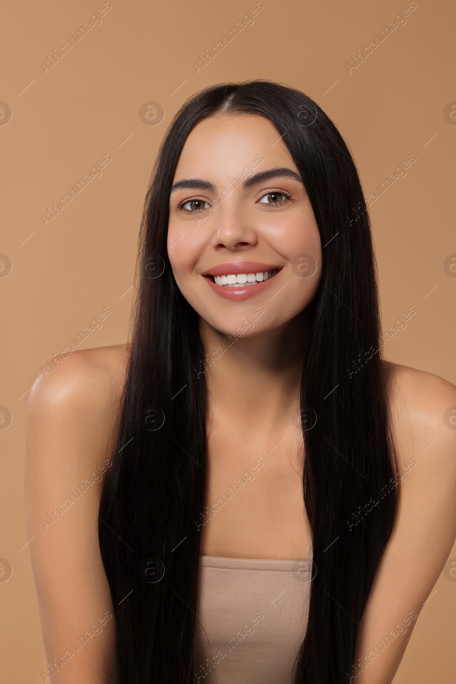 Photo of Beautiful woman with long hair on beige background