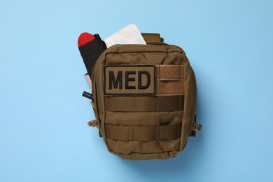 Photo of Military first aid kit on light blue background, top view