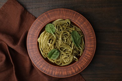 Photo of Tasty pasta with spinach on wooden table, top view