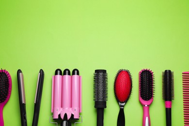 Photo of Flat lay composition of professional hairdresser tools on light green background, space for text