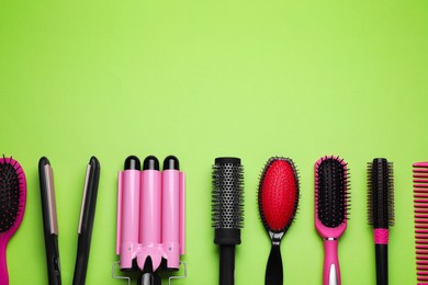 Flat lay composition of professional hairdresser tools on light green background, space for text