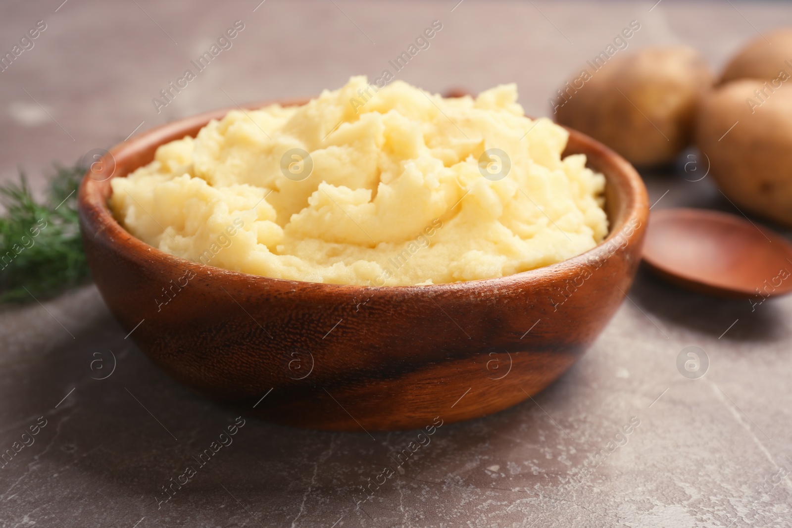 Photo of Bowl with mashed potatoes on grey table