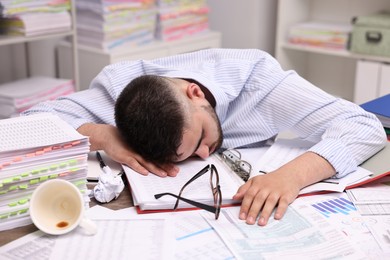 Office worker sleeping at workplace. Overwhelmed by work