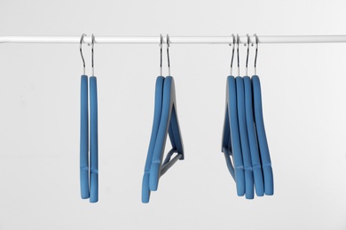 Photo of Metal rack with clothes hangers on white background