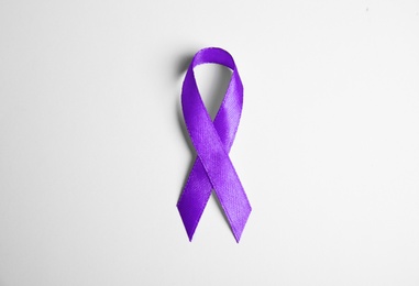 Purple ribbon on white background, top view. Domestic violence awareness