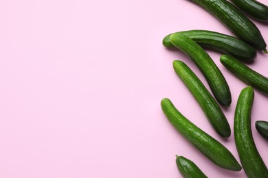 Photo of Fresh ripe cucumbers on pink background, flat lay. Space for text