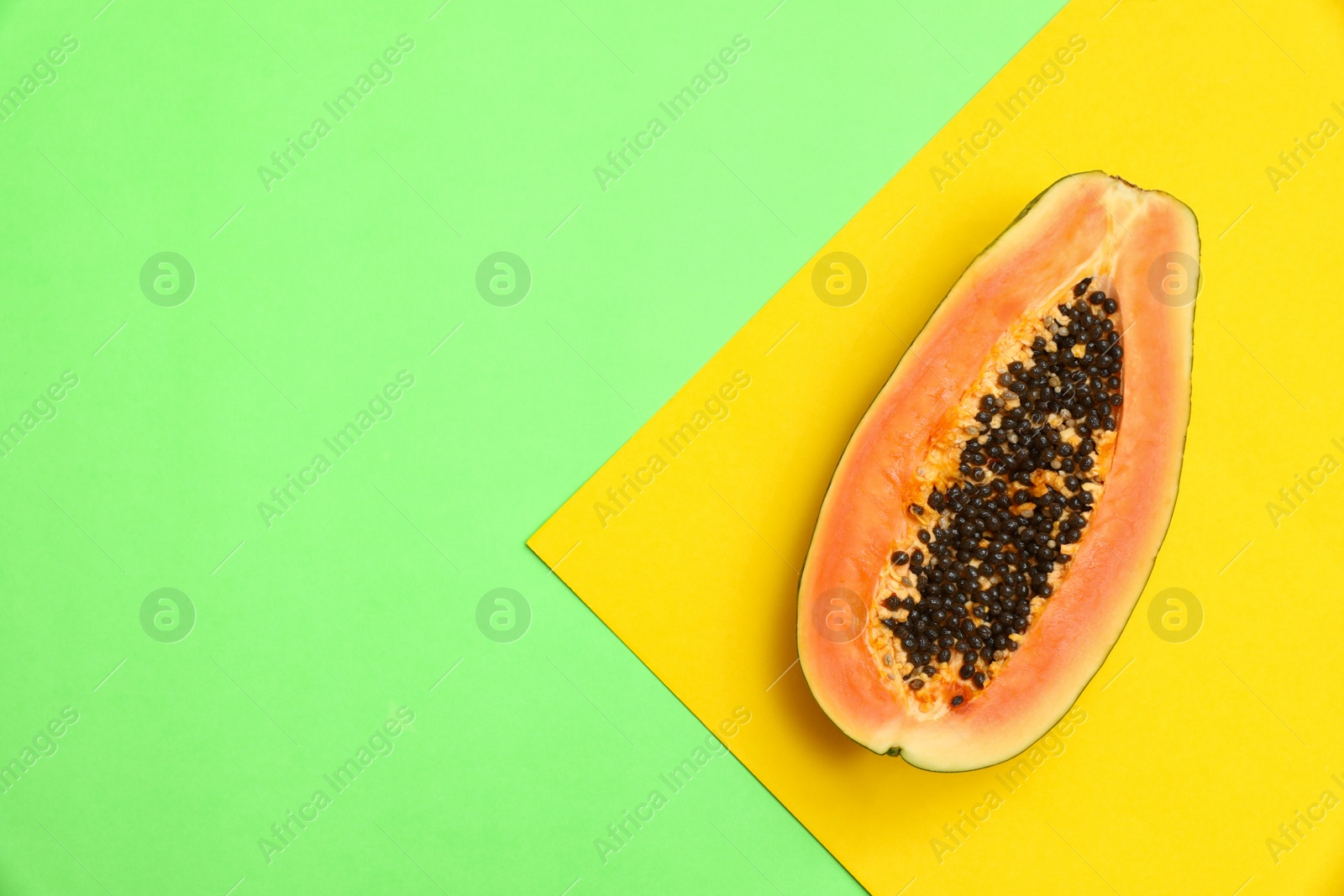 Photo of Fresh juicy halved papaya on color background, top view. Space for text