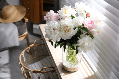 Photo of Bouquet of beautiful peony flowers on window sill indoors. Space for text