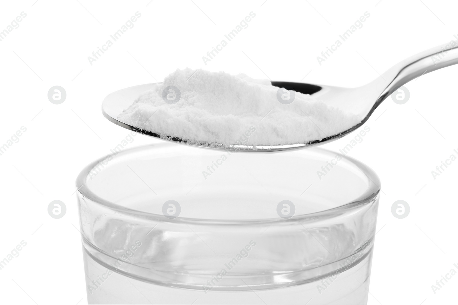 Photo of Spoon with baking soda over glass of water on white background