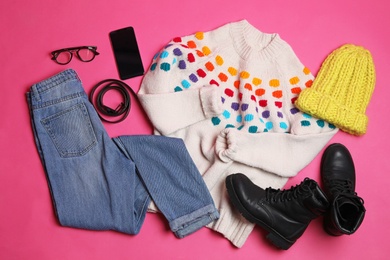 Photo of Flat lay composition with winter clothes and boots on pink background