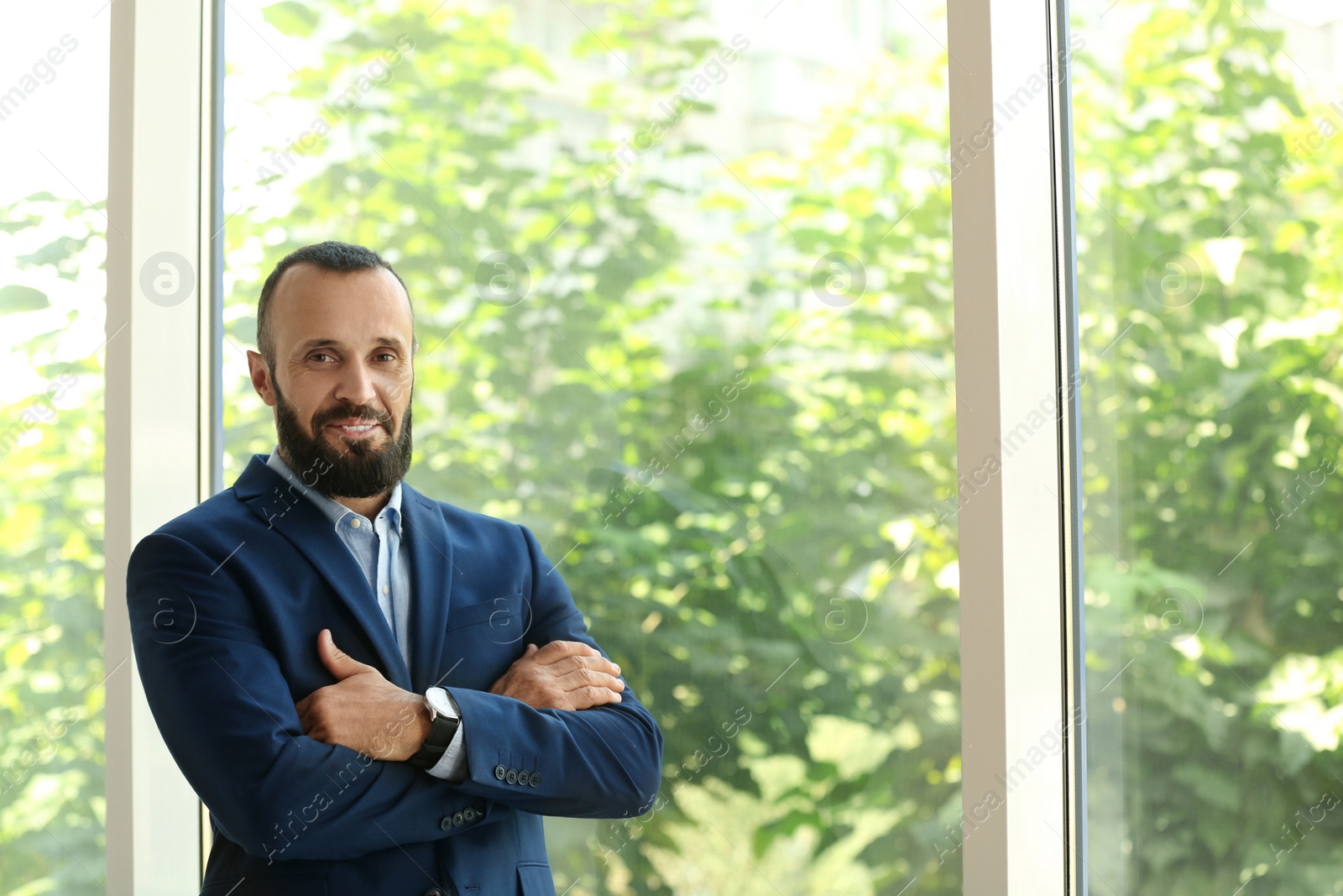 Photo of Portrait of handsome mature man in elegant suit near window. Space for text