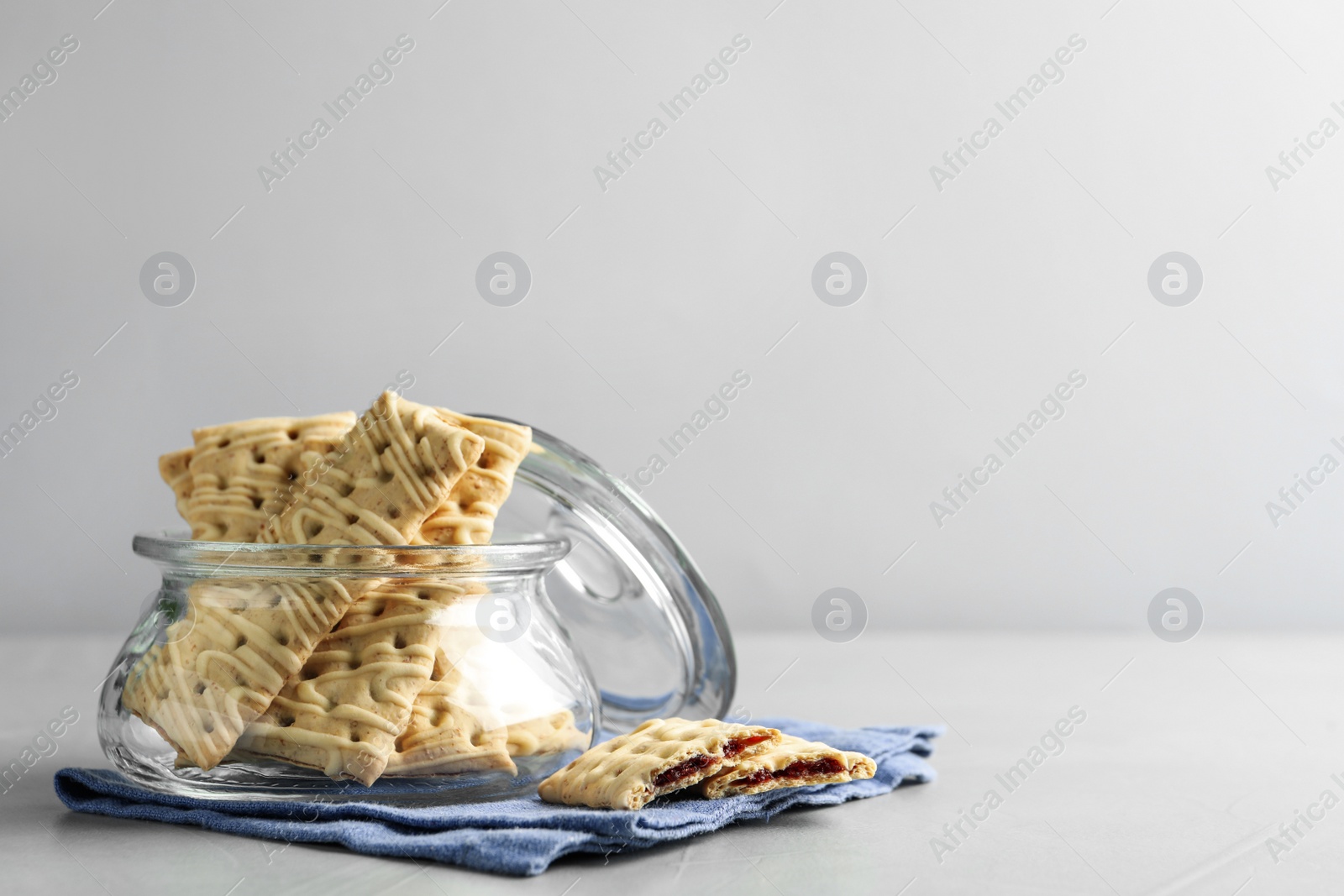 Photo of Tasty cookies with filling on light grey table. Space for text