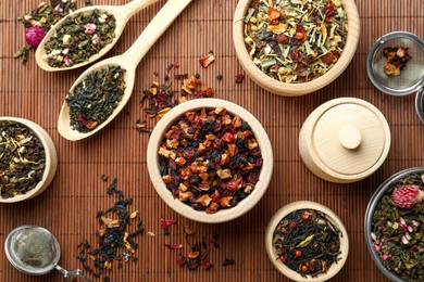 Photo of Many different herbal teas on bamboo mat, flat lay