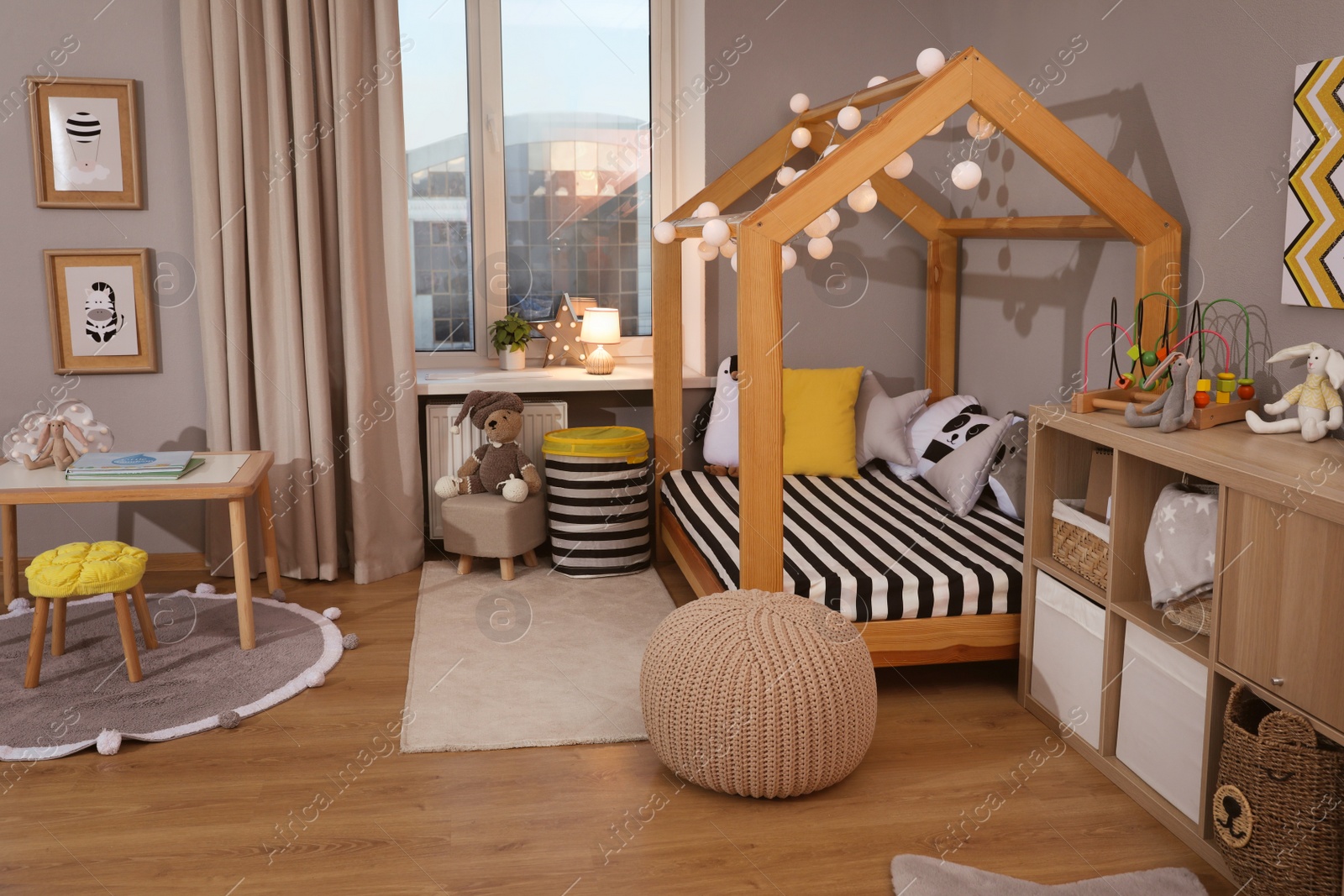 Photo of Stylish child room interior with comfortable house bed and toys