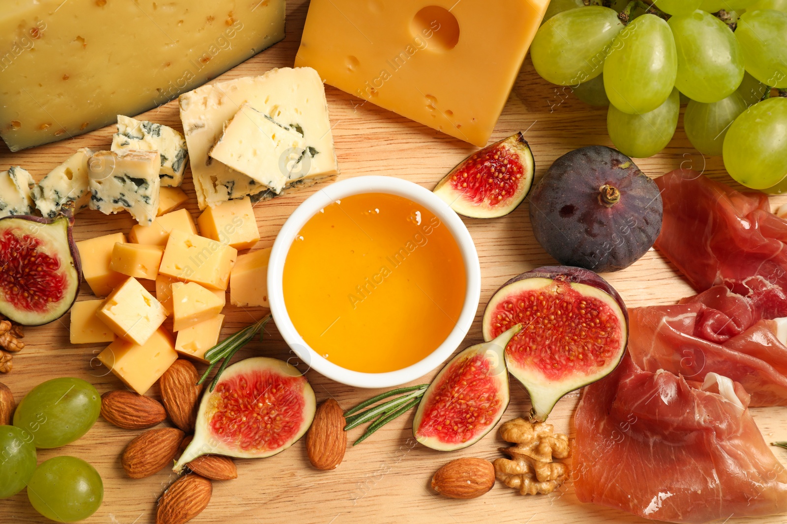 Photo of Set of different snacks with ripe figs served on wooden table, flat lay