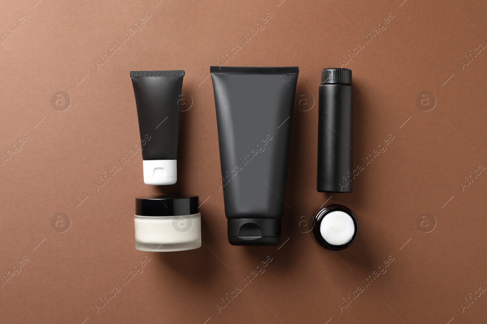 Photo of Facial cream and other men's cosmetic products on brown background, flat lay