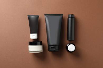 Photo of Facial cream and other men's cosmetic products on brown background, flat lay