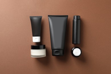 Facial cream and other men's cosmetic products on brown background, flat lay