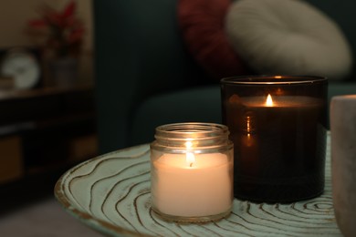 Lit candles on table in living room. Space for text