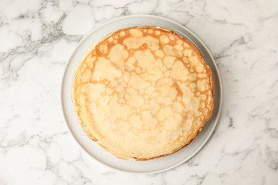 Photo of Stack of fresh thin pancakes on white marble table, top view