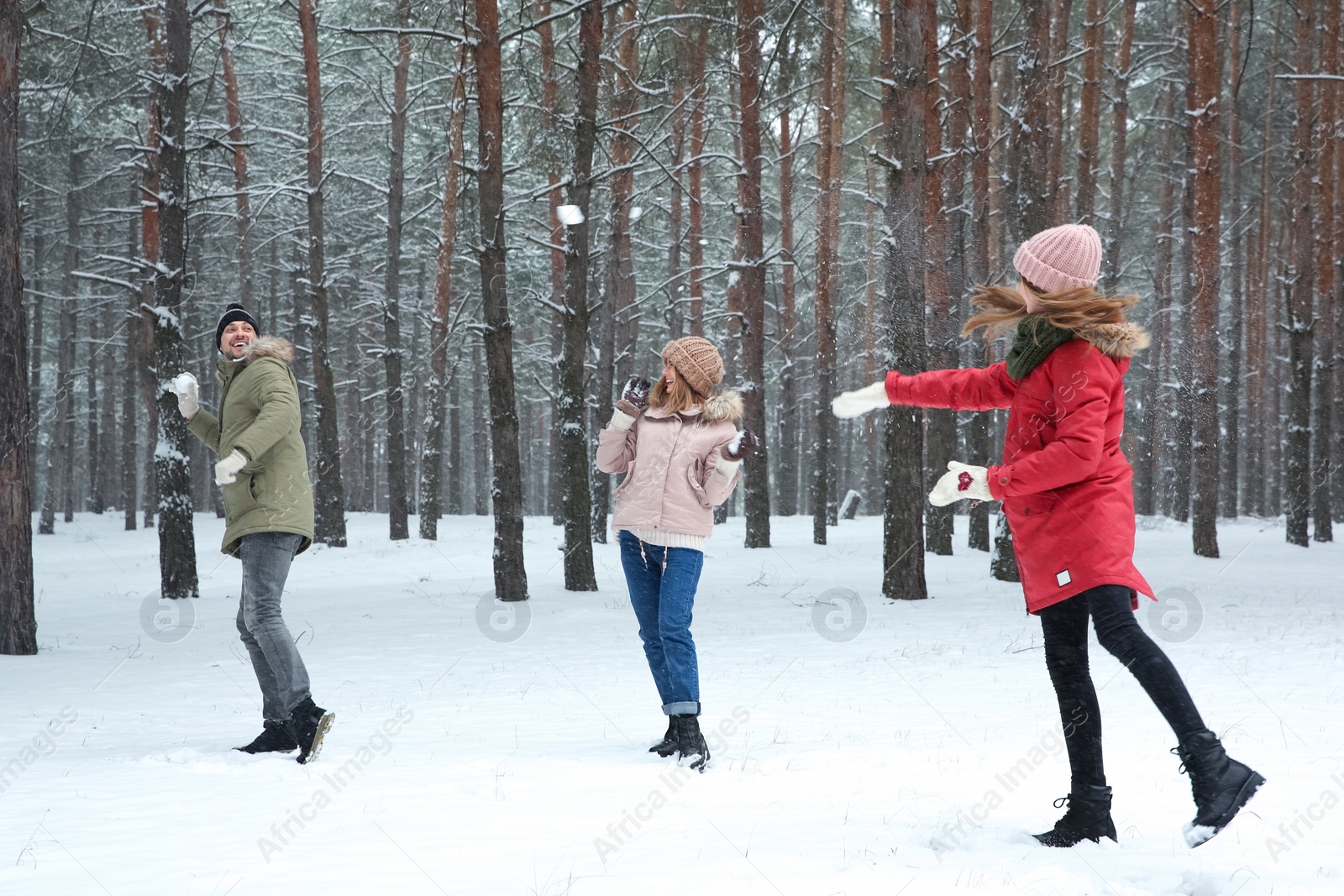 Photo of Happy family playing snowballs in winter forest