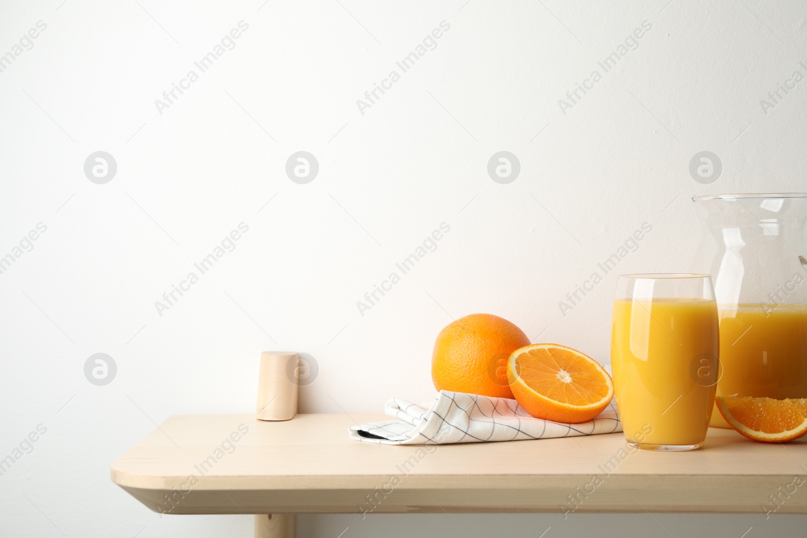 Photo of Orange juice and fresh fruits on wooden table. Space for text