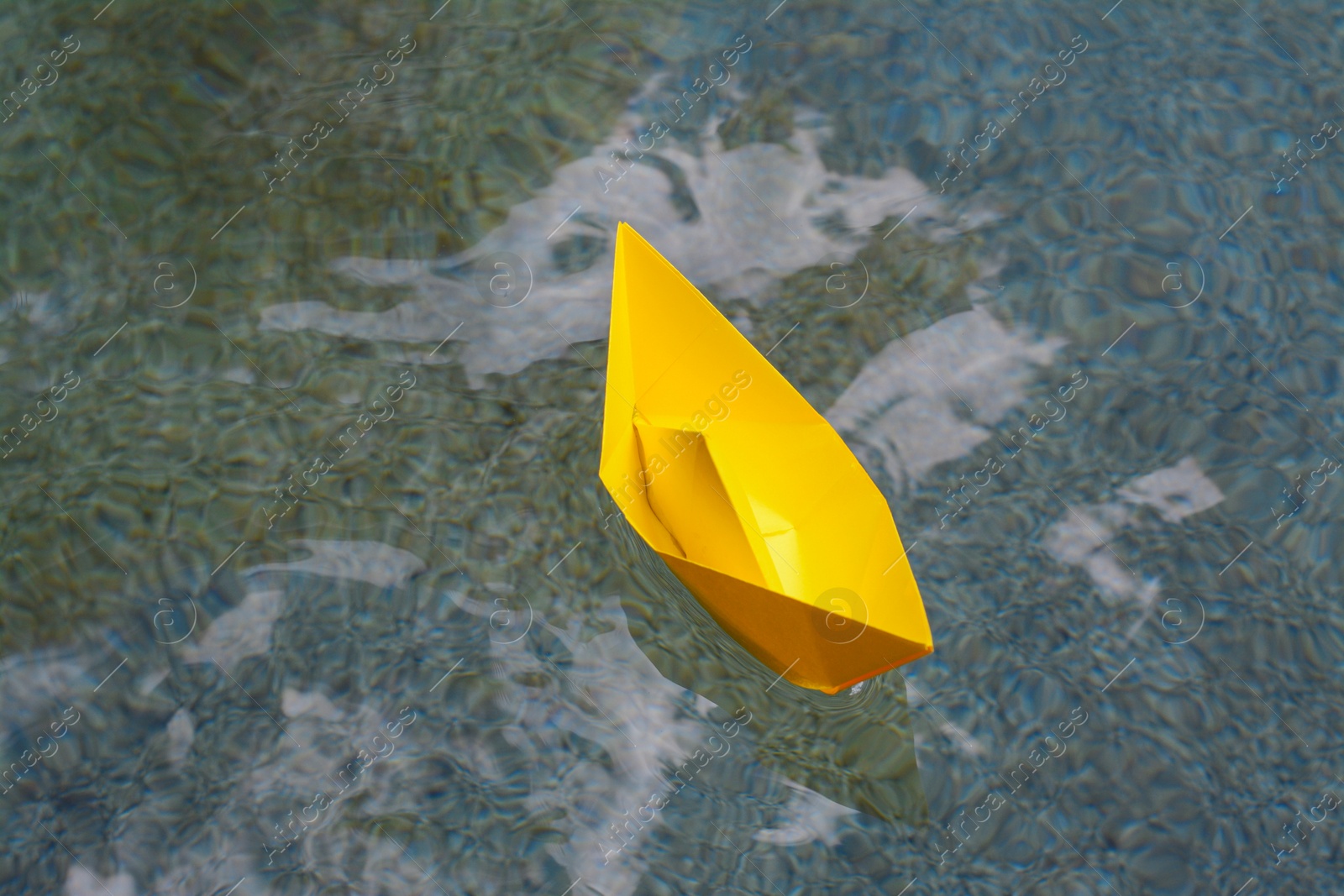 Photo of Beautiful yellow paper boat on water outdoors