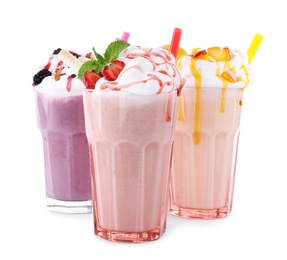 Photo of Different tasty milk shakes in glasses on white background