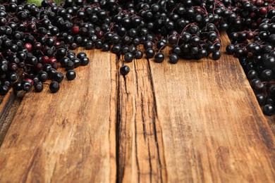 Photo of Elderberries (Sambucus) on wooden table. Space for text