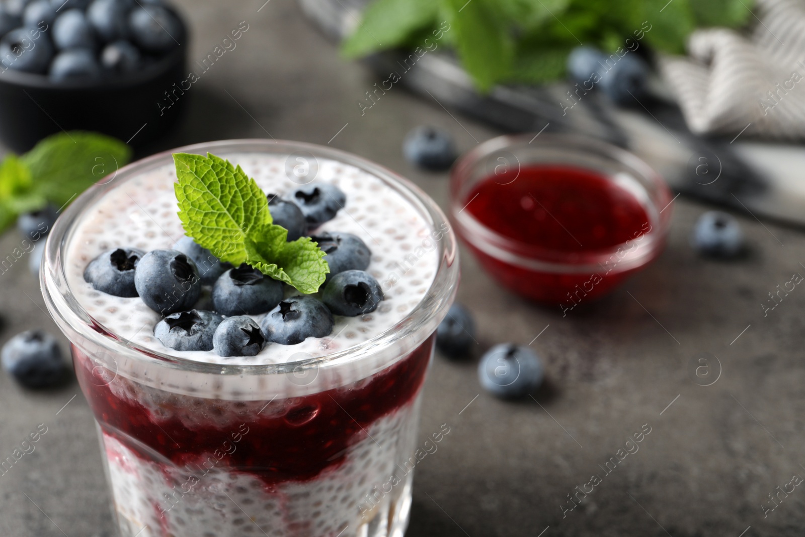 Photo of Delicious chia pudding with blueberries on grey table