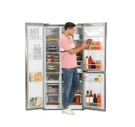 Photo of Man taking pickles from refrigerator on white background