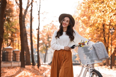 Beautiful happy woman with bicycle in autumn park