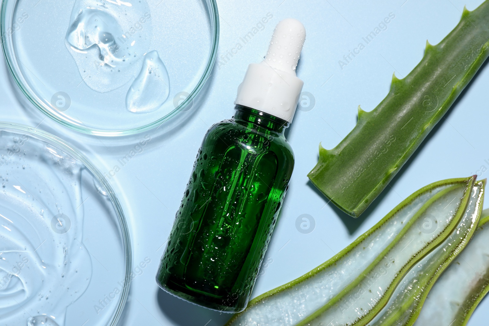 Photo of Cosmetic products and cut aloe vera on light blue background, flat lay