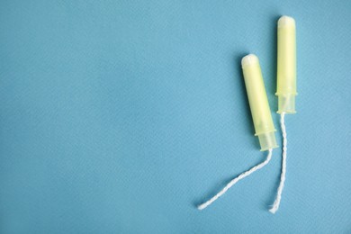 Tampons on turquoise background, flat lay. Space for text