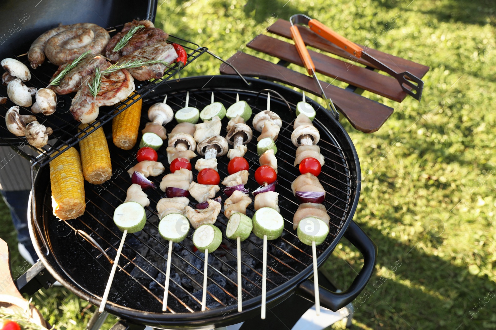 Photo of Cooking meat and vegetables on barbecue grill outdoors