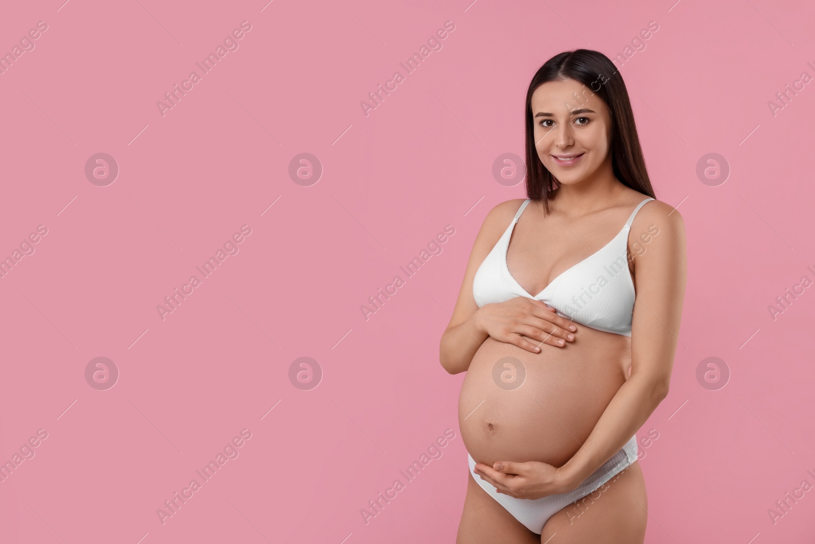 Photo of Beautiful pregnant woman in stylish comfortable underwear on pink background, space for text