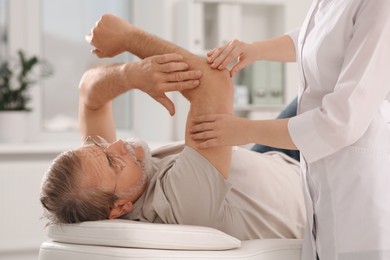 Professional orthopedist examining patient's arm in clinic