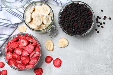 Photo of Many different freeze dried fruits on light grey table, flat lay