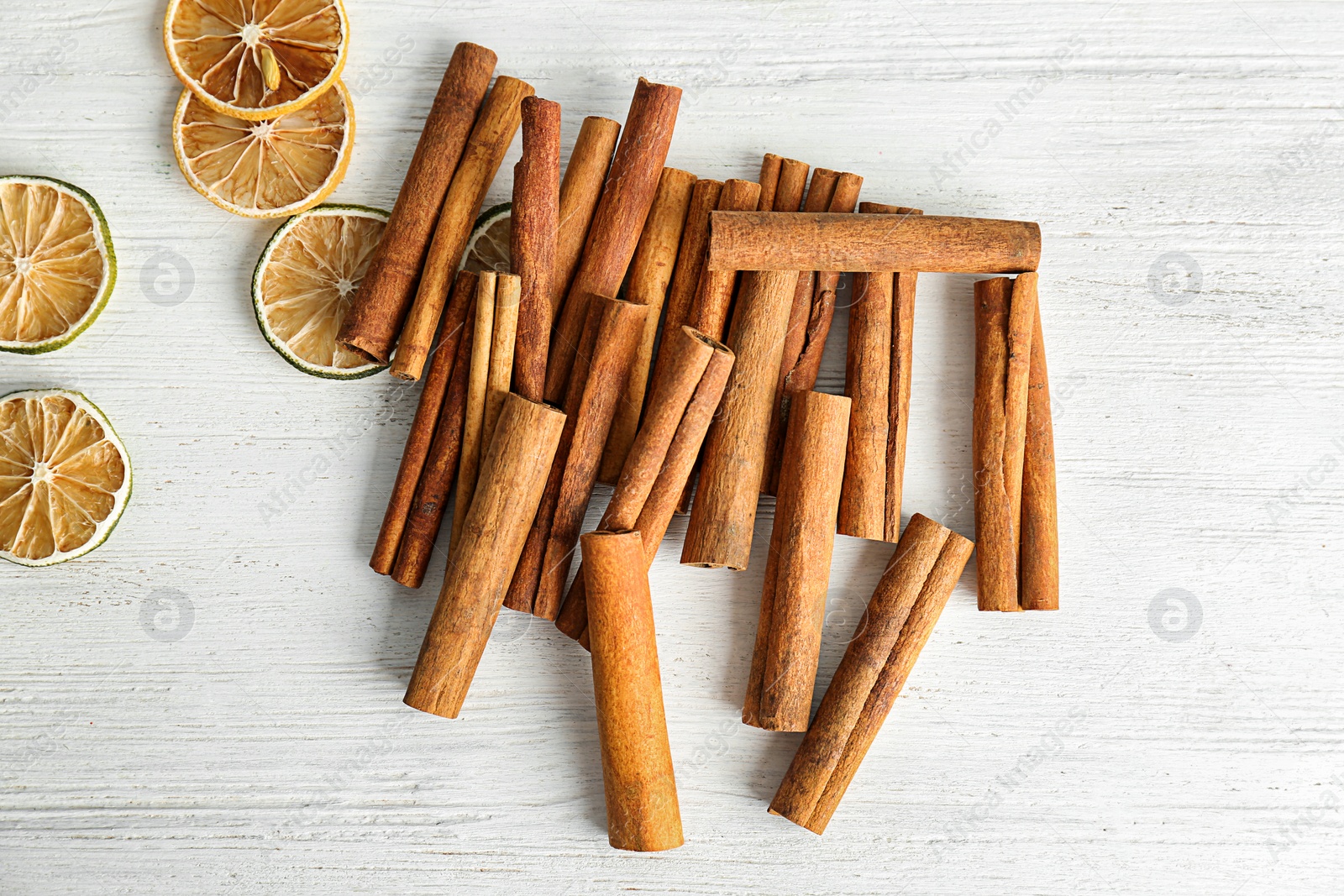 Photo of Aromatic cinnamon sticks and lime slices on wooden background