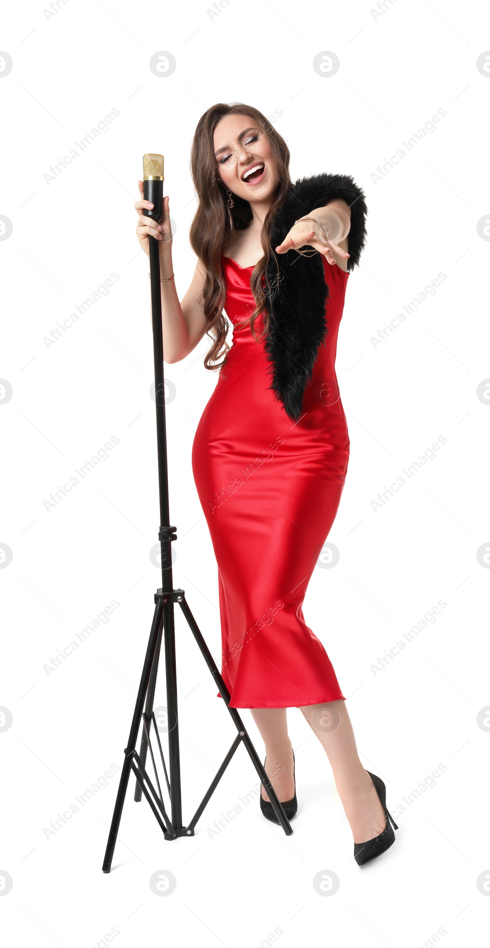 Photo of Beautiful young woman in stylish red dress with microphone singing on white background