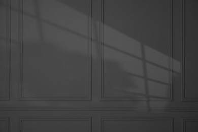 Shadow from window on dark grey wall indoors