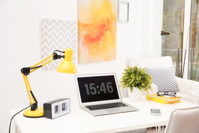 Stylish workplace with laptop on table in room